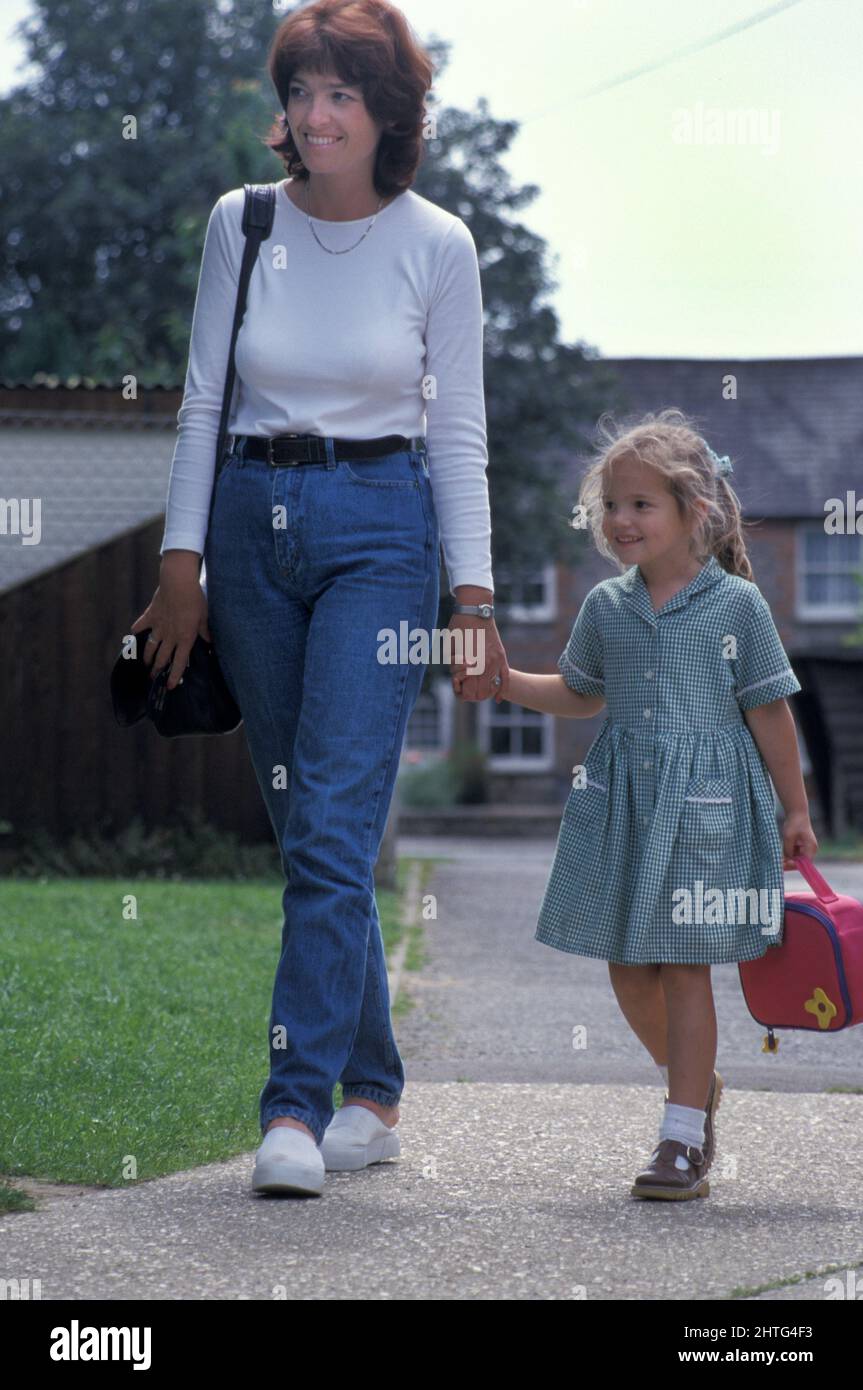 mother walking little girl to school on her first day Stock Photo