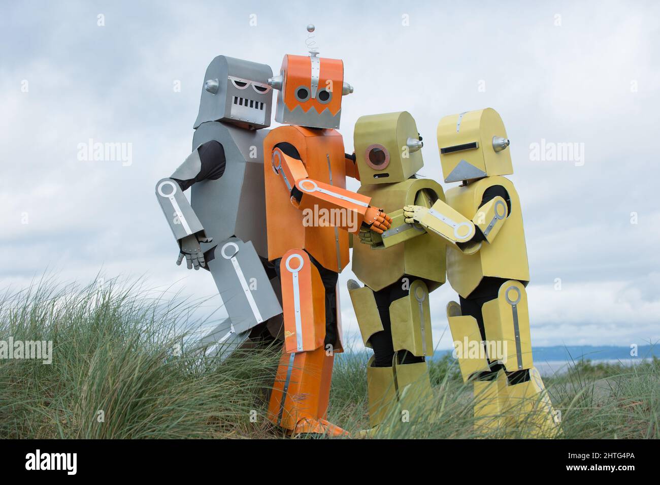 Robot family posing for a photo. Robots like people. Robots being photographed while being outside. Stock Photo