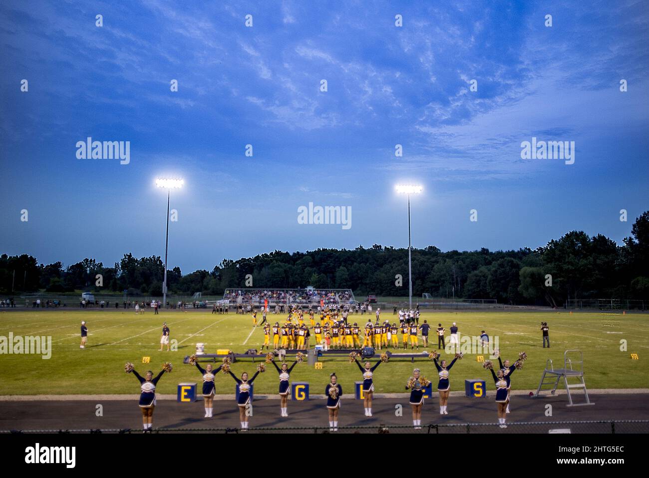 Classic High school football game with football players and cheerleaders Stock Photo