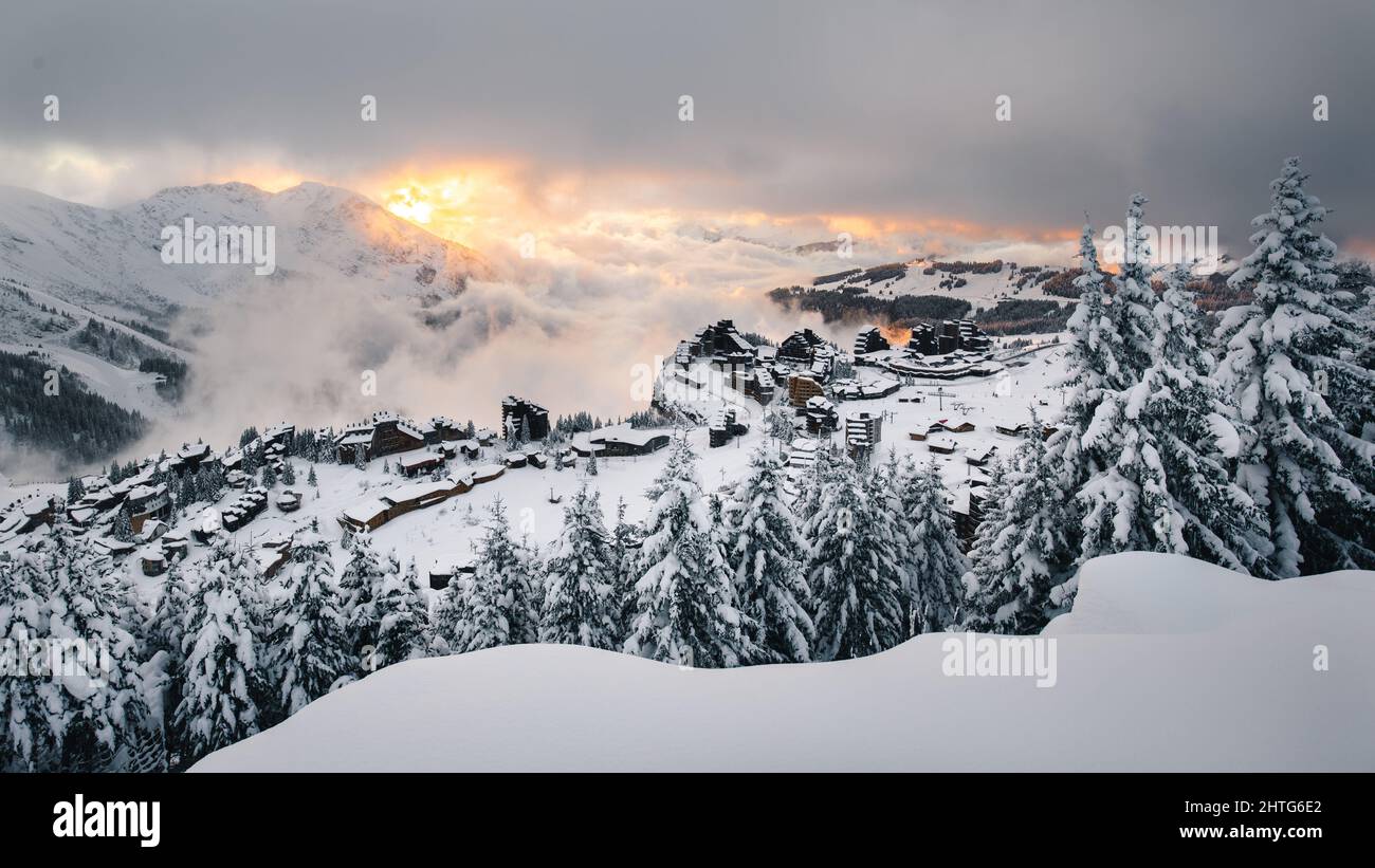 Sunset at the ski resort with with snow-capped mountains and gray ...