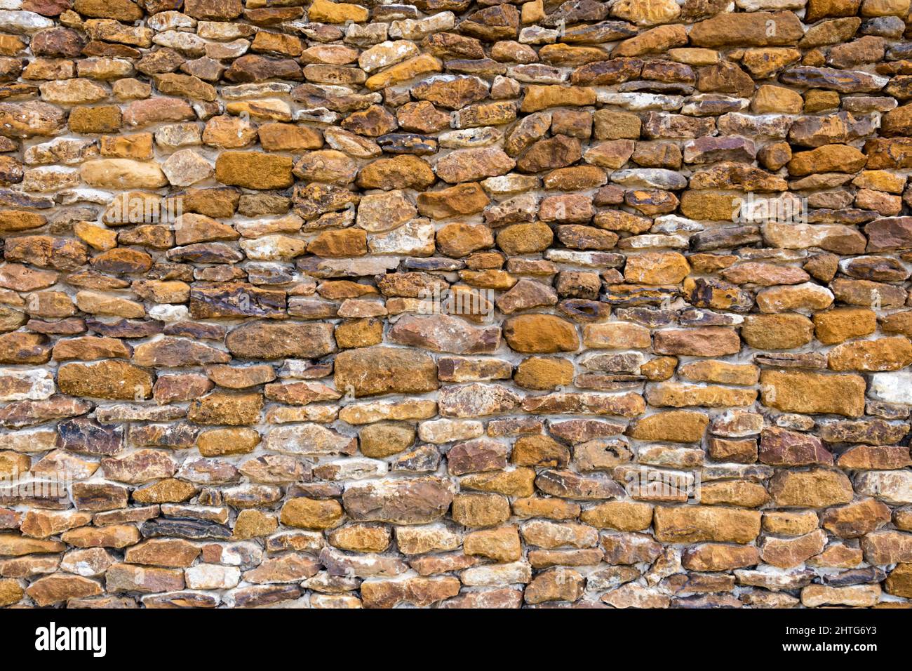 Small blocks of carstone or carrstone used as a building material in the side of a West Norfolk building. Stock Photo