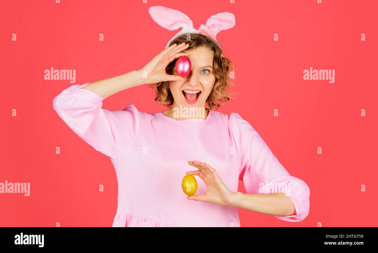Happy Easter. Egg hunt. Girl with color eggs. Smiling woman in rabbit bunny ears prepare for Easter. Stock Photo