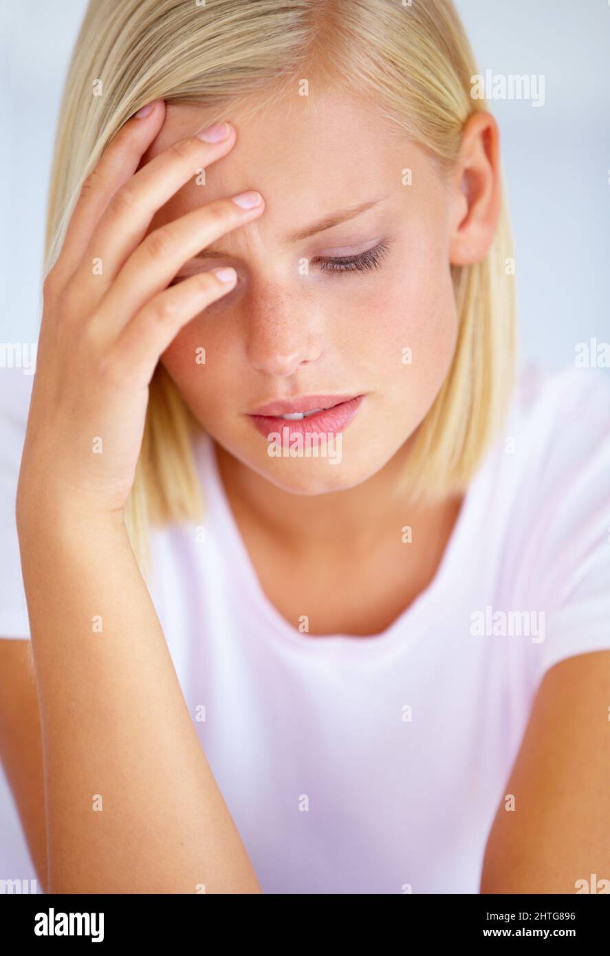Stressed out. A worried young woman sitting in her bed. Stock Photo
