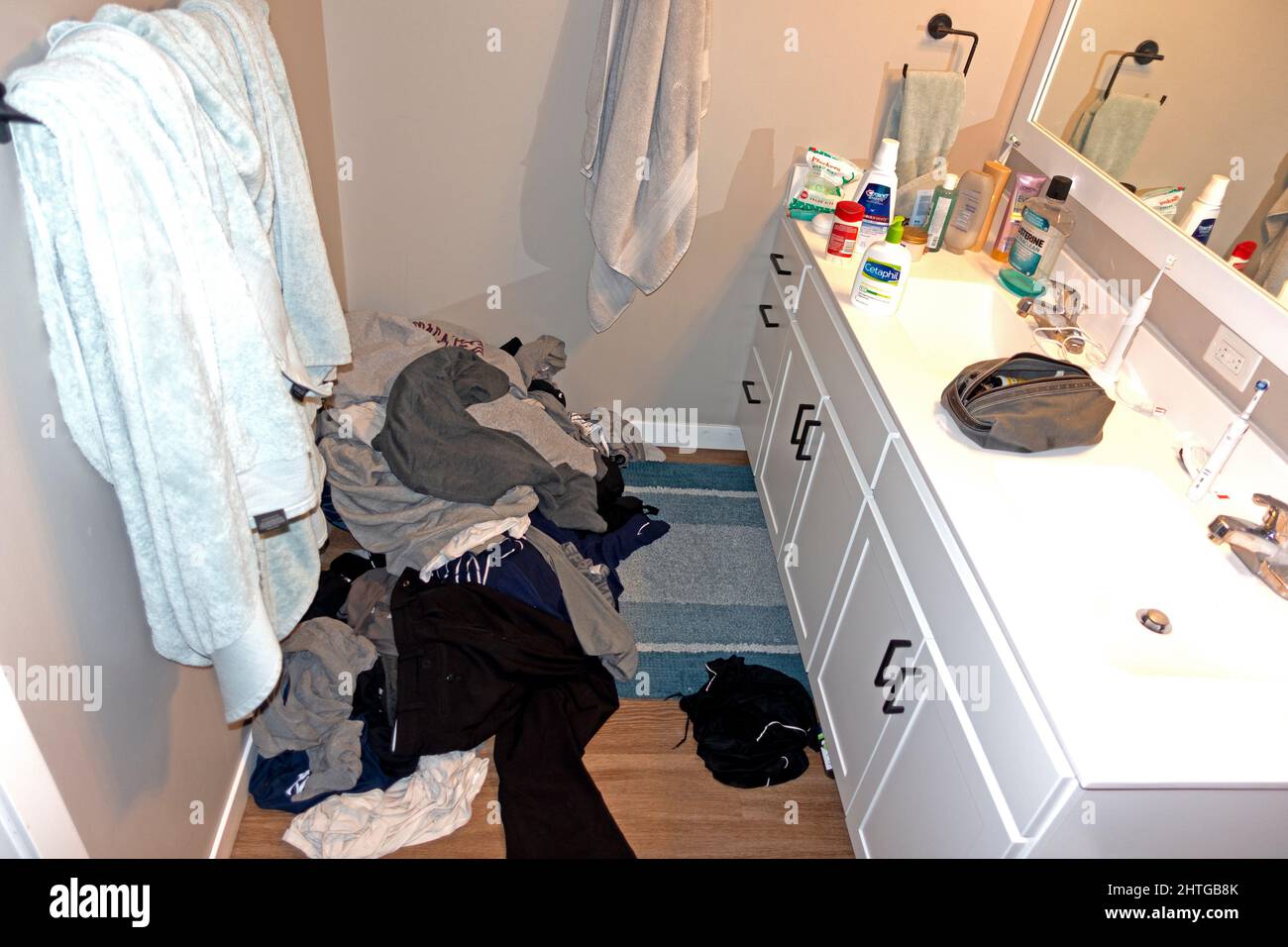 Messy tangle of clothes on the floor in a young men's bathroom. St Paul Minnesota MN USA Stock Photo