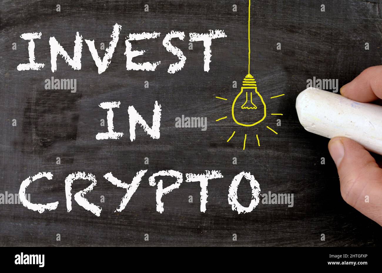 Invest in crypto blackboard with lamp as an idea symbol Stock Photo