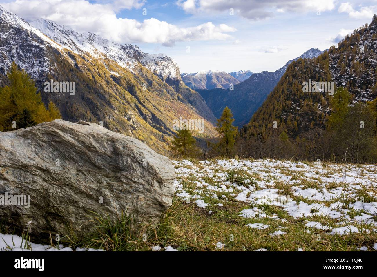 Alpine valley in autumn after a small snowfall with rocks on the ...
