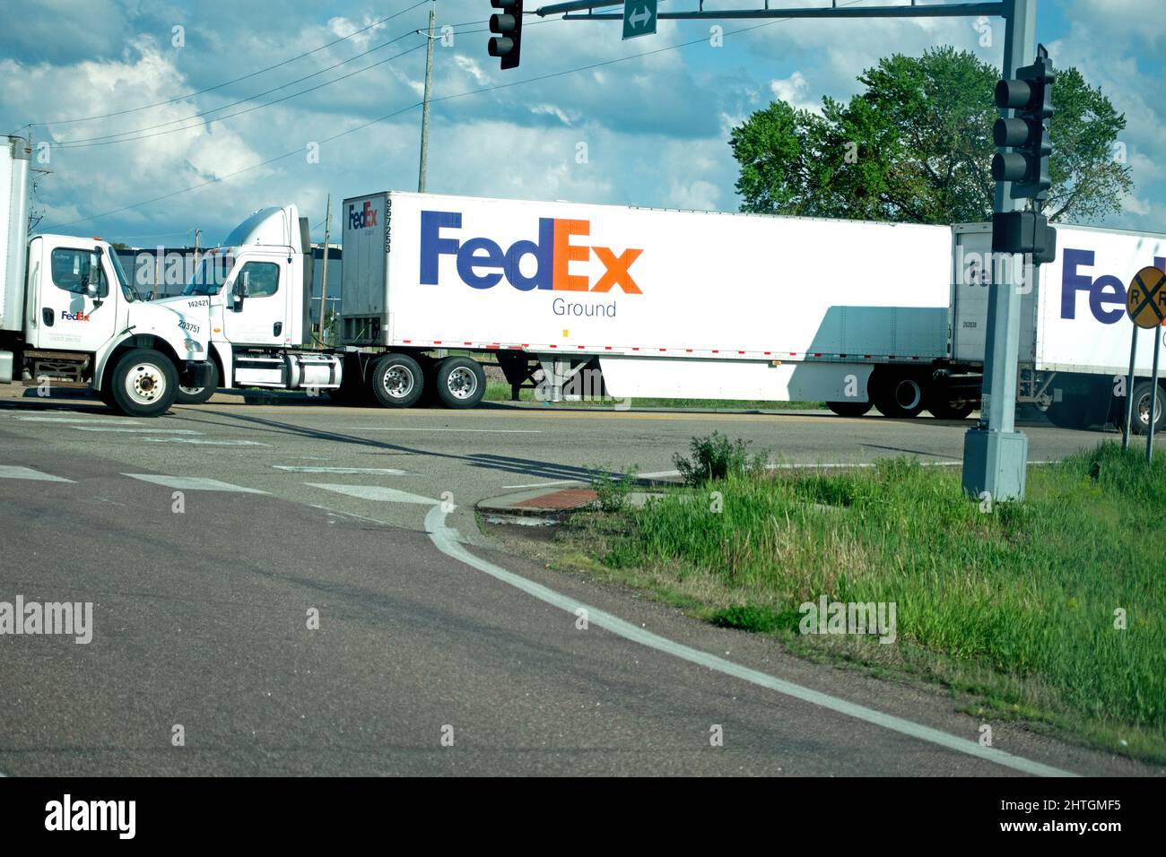 FedEx semi trucks lined up for deliveries at an intersection. Shakopee Minnesota MN USA Stock Photo