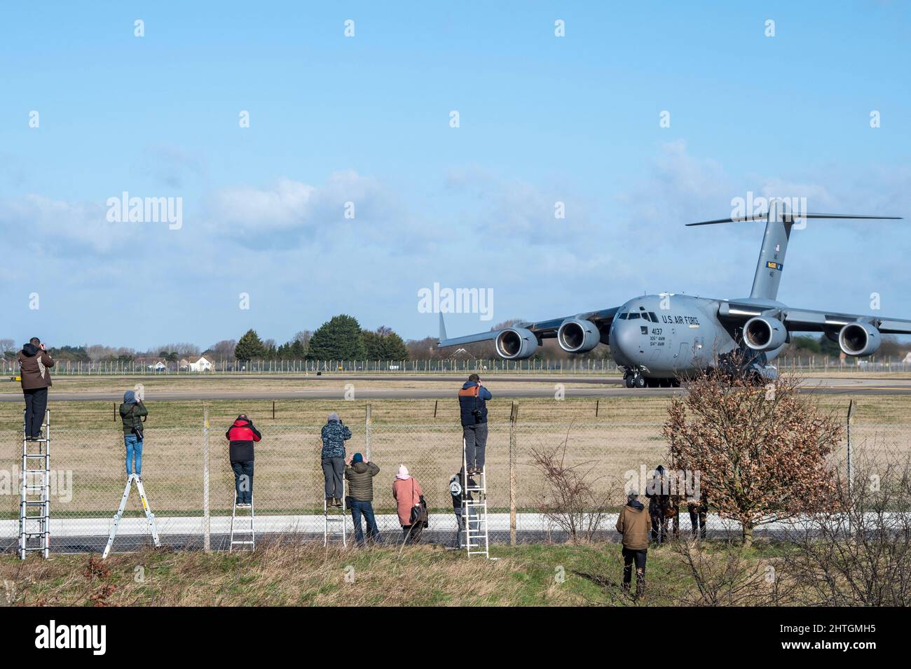 Plane spotters at Mildehall Air Field taking pictures of  Boeing C-17 Globemaster III taxi-ing Stock Photo