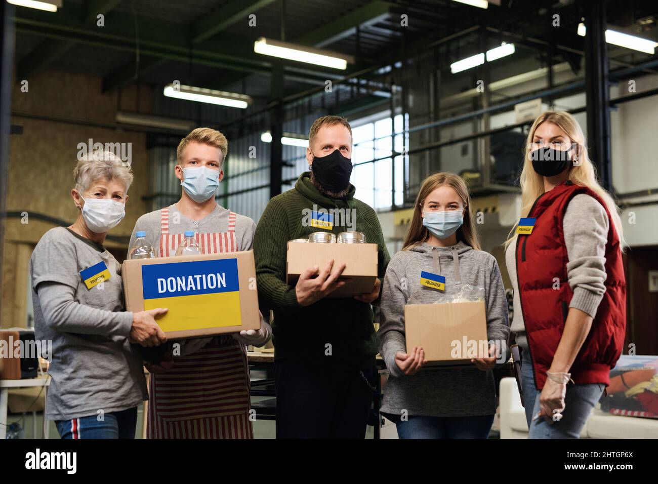 Group of volunteers helping in Ukrainian refugee centre looking at camera, Russian conflict concept. Stock Photo