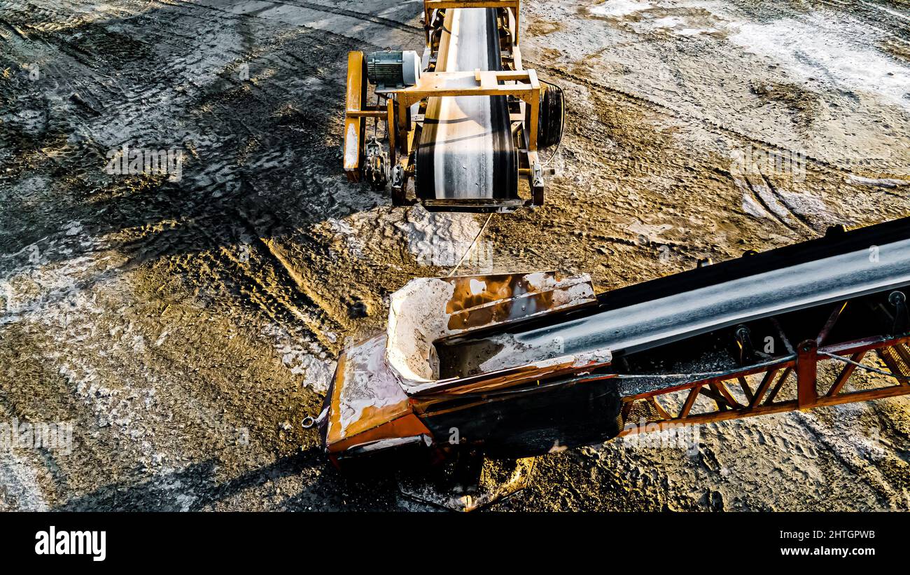 Open pit rock quarry with stone traveling on conveyors to piles Stock Photo