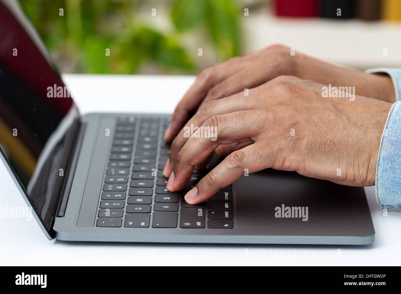 Closeup shot of an unrecognizable man working on a laptop at home Stock Photo