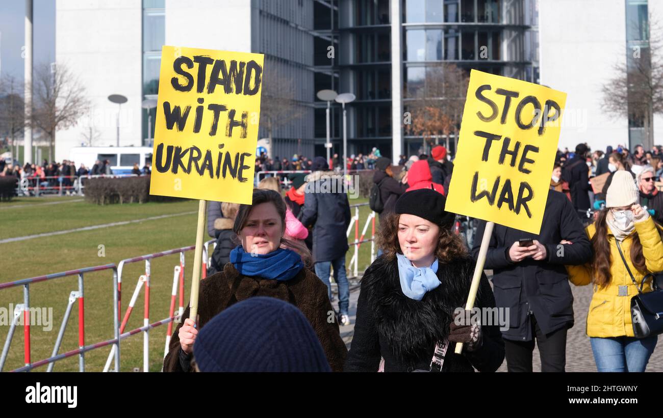 People with Ukrainian anti war placards participate in a protest against the war in Ukraine. Stock Photo