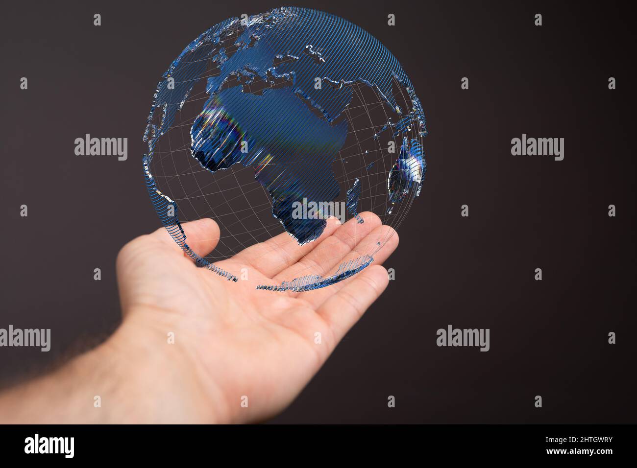 Floating globe over a hand against a dark background-global network concept Stock Photo