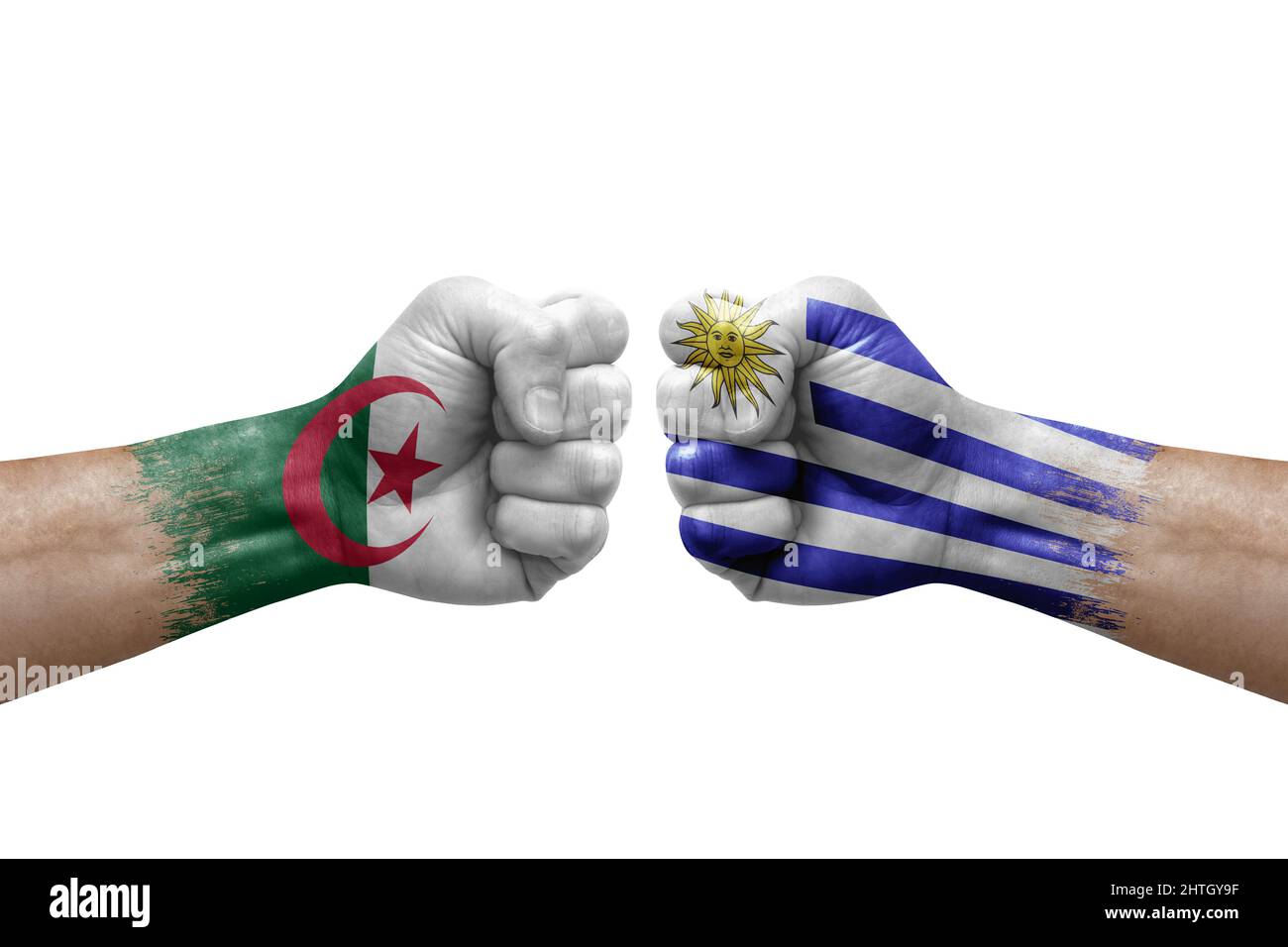 Two hands punch to each others on white background. Country flags painted fists, conflict crisis concept between algeria and uruguay Stock Photo