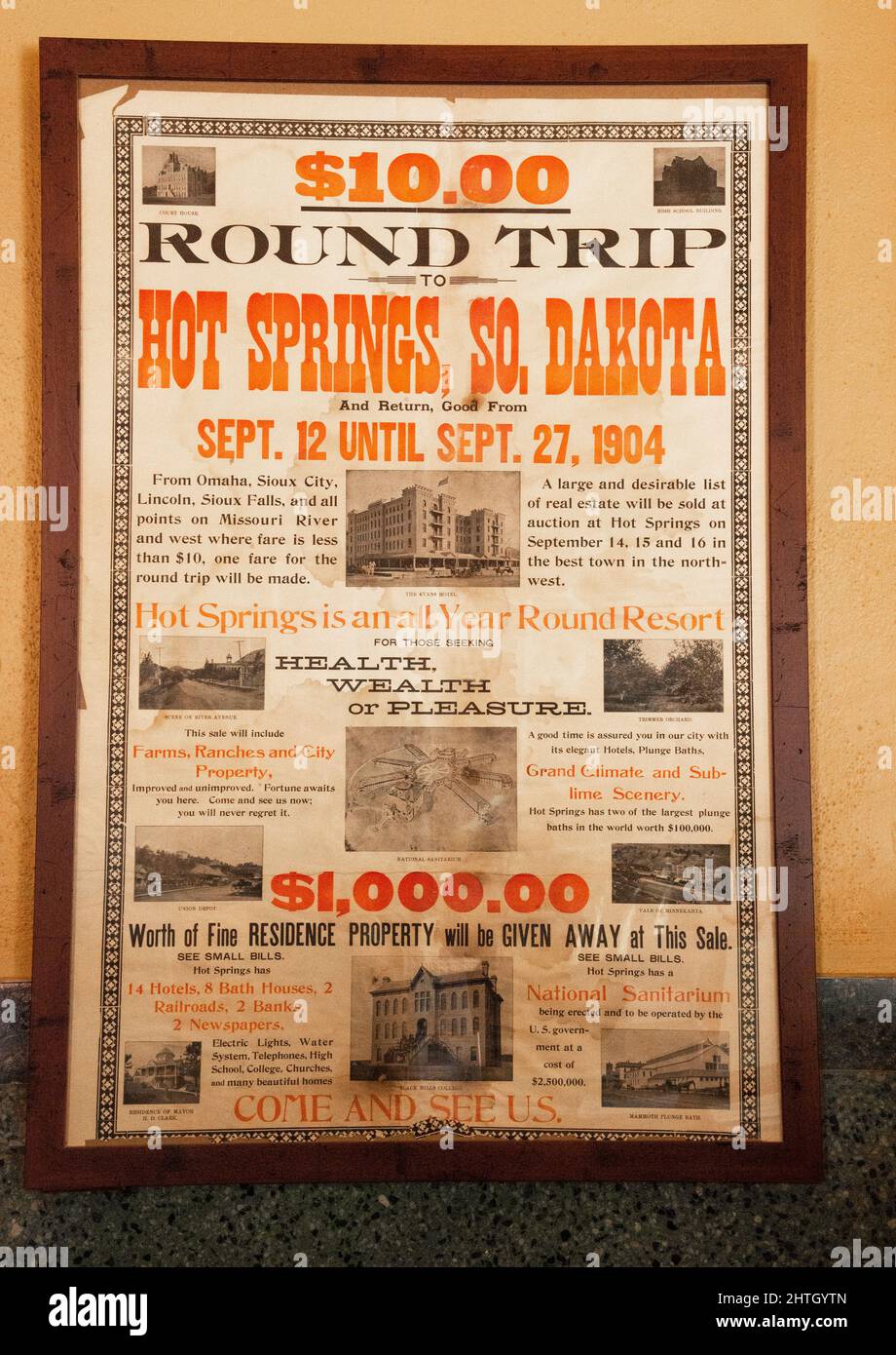 Old poster advertisement about coming to Hot Springs, South Dakota by train for ten dollars roundtrip and real estate up for sale Stock Photo