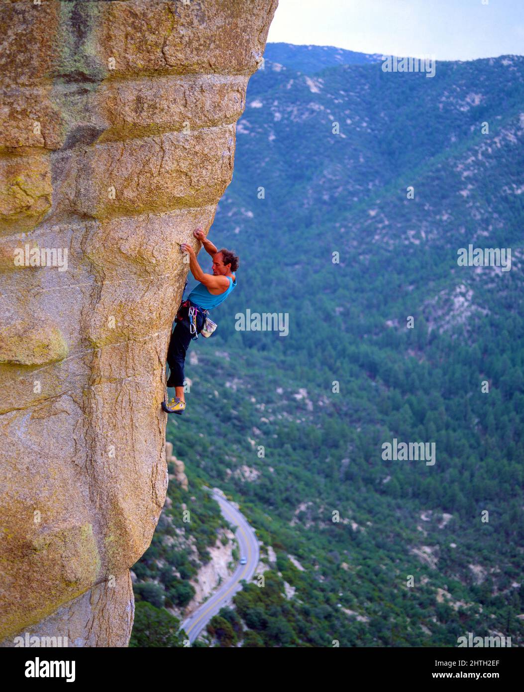 Single male climber ascends a steep rock formation in the Santa