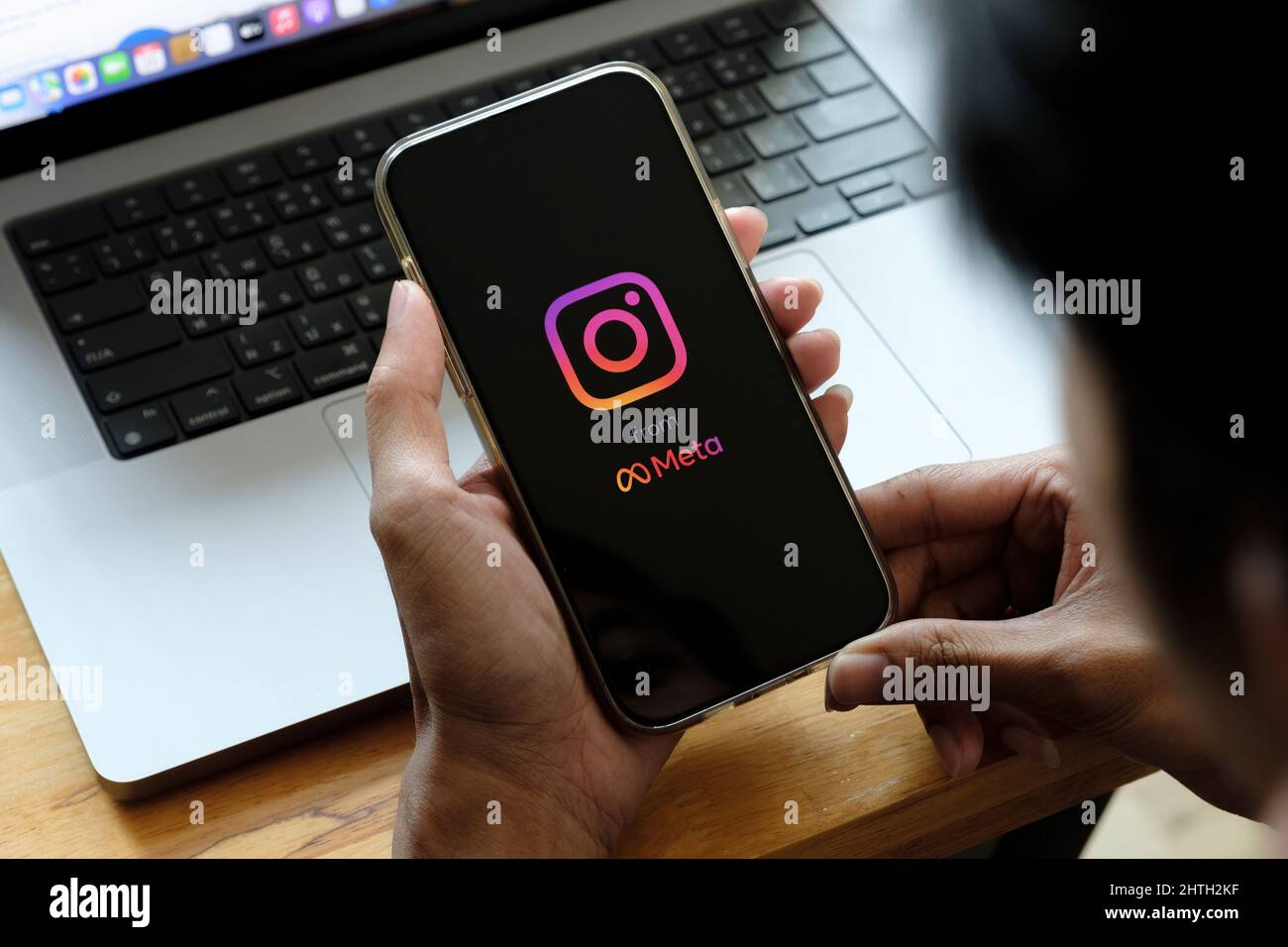 CHIANG MAI, THAILAND - FEB 26 2022: A man holds Apple iPhone 13 with Instagram application on the screen at cafe. Instagram from meta is a photo Stock Photo