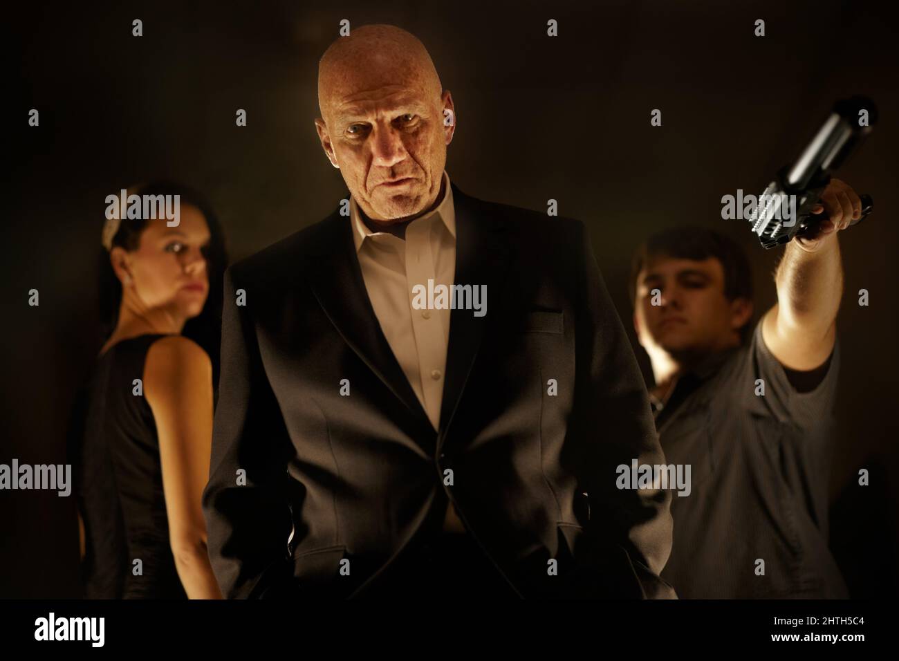 Crime is his game. Mob boss looking serious with his team standing behind him. Stock Photo