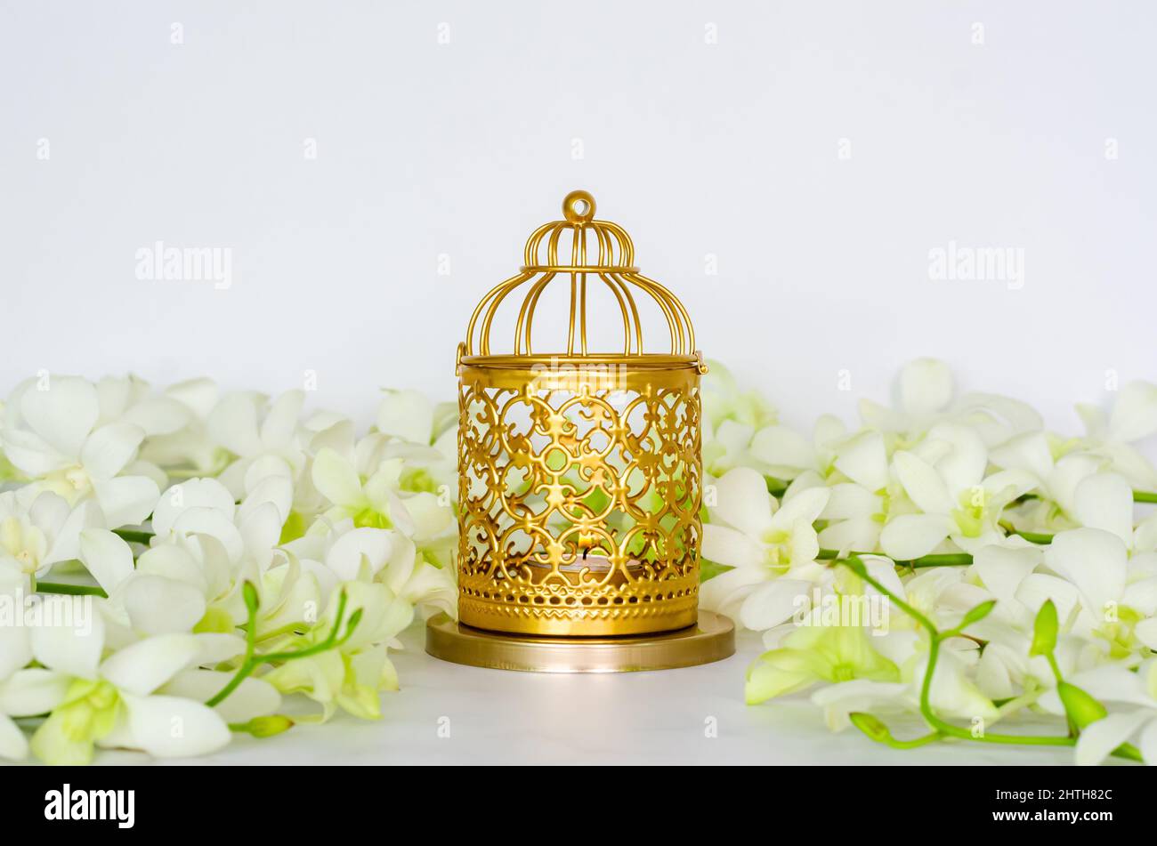 Golden lantern with white orchid flower for the Muslim feast of the holy month of Ramadan Kareem. Stock Photo