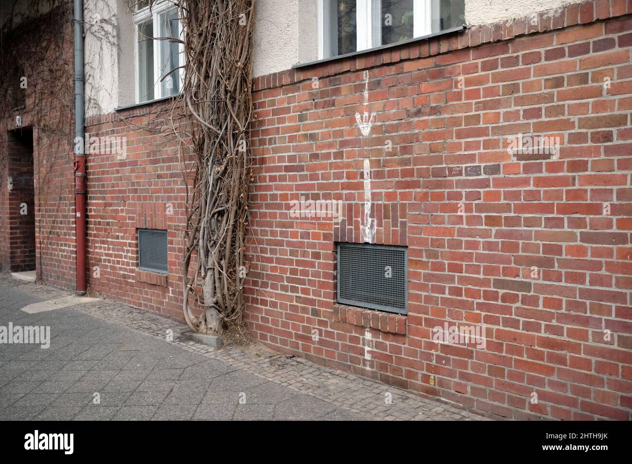Leipzig, Germany. 28th Feb, 2022. Arrows point to a basement window on the facade of a residential building in the Gohlis district. During the Second World War, this was a sign for the civilian population to access an air-raid shelter. Even today, hidden witnesses of the Second World War can still be found. Credit: Sebastian Willnow/dpa-Zentralbild/dpa/Alamy Live News Stock Photo