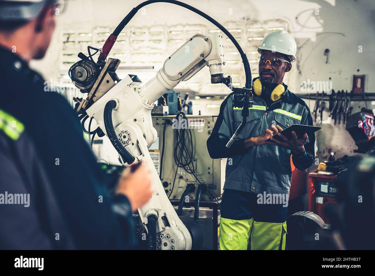 Factory workers working with adept robotic arm in a . Industry