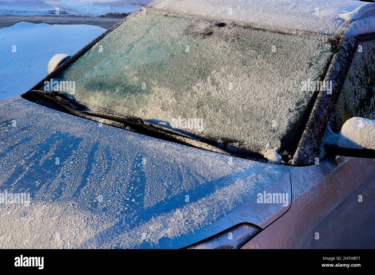 The windshield covered with frost at the car on a sun winter day Stock