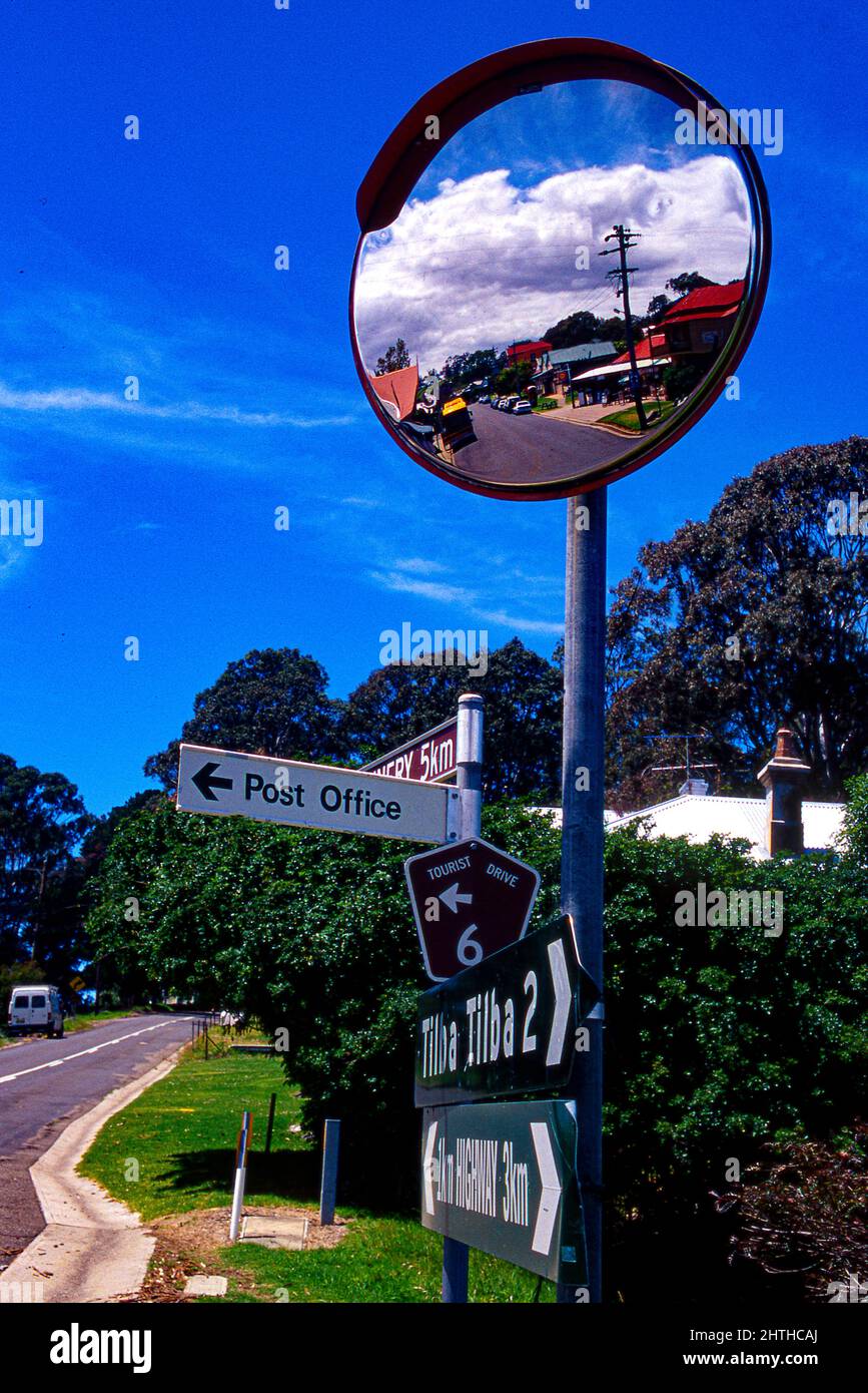 Central Tilba, seen reflected in traffic mirror, is a picturesque village on the South Coast of New South Wales and is classified by the National Trus Stock Photo