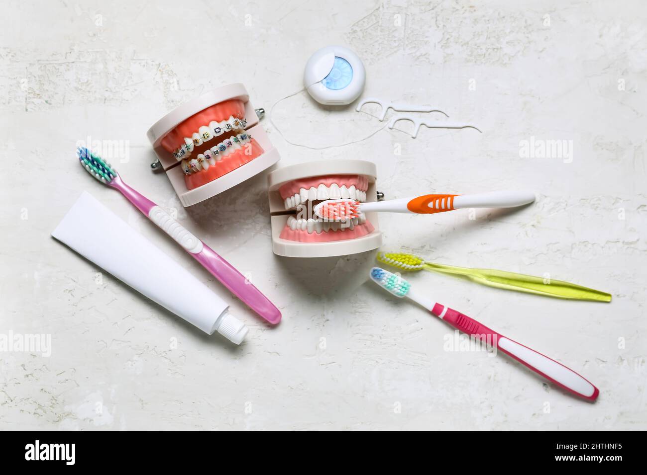 Model of jaws with braces, toothbrushes, paste and dental floss on ...