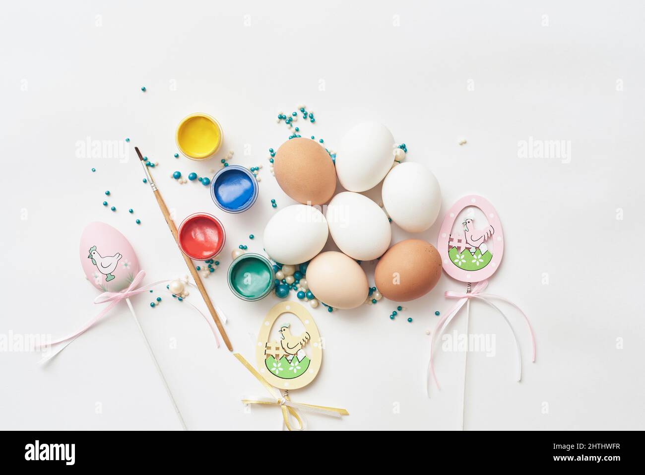 Template in easter theme with eggs and paint on white background Stock Photo