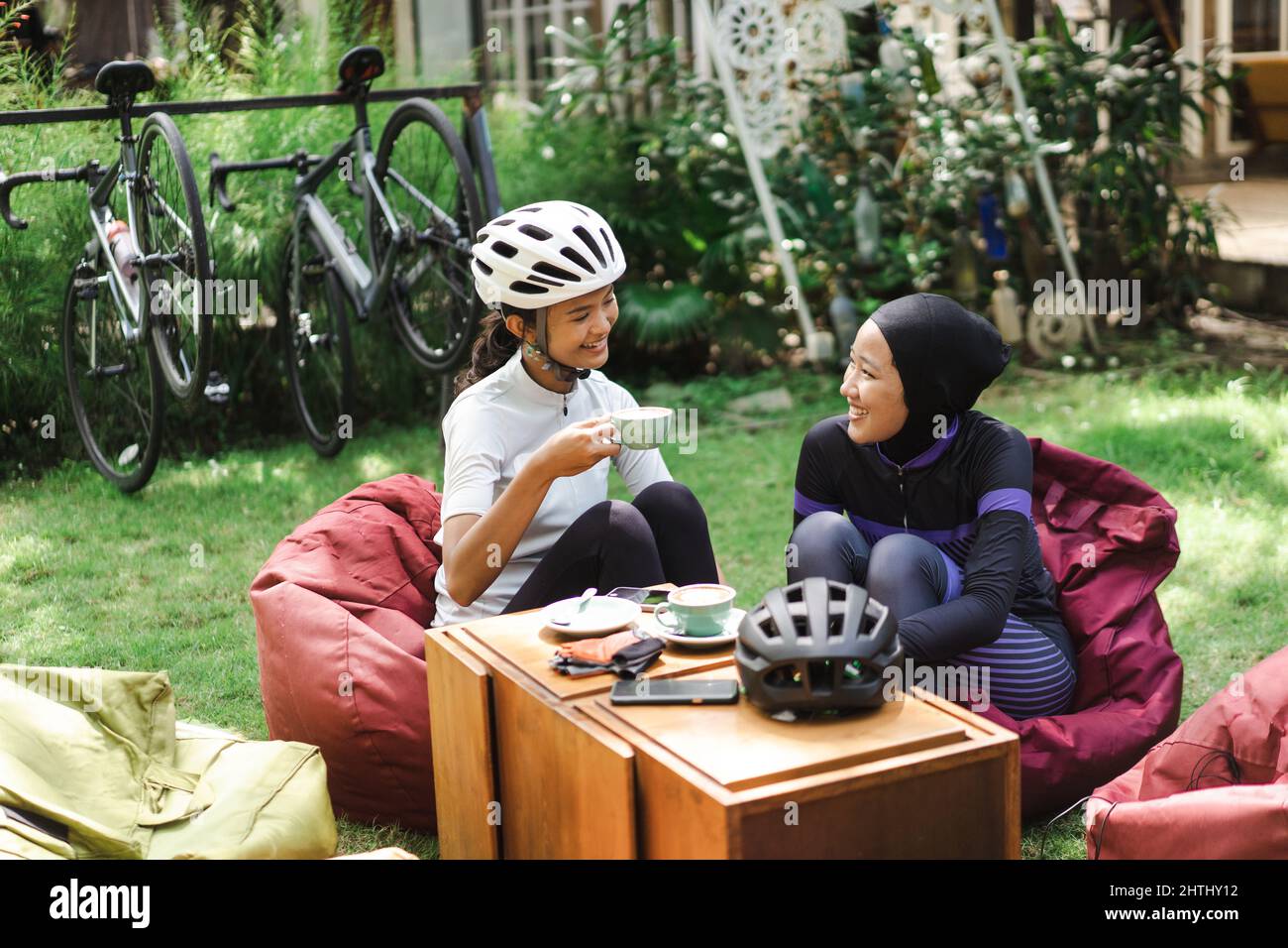 asian bicycle rider drinking coffee in the cafe after cycling Stock