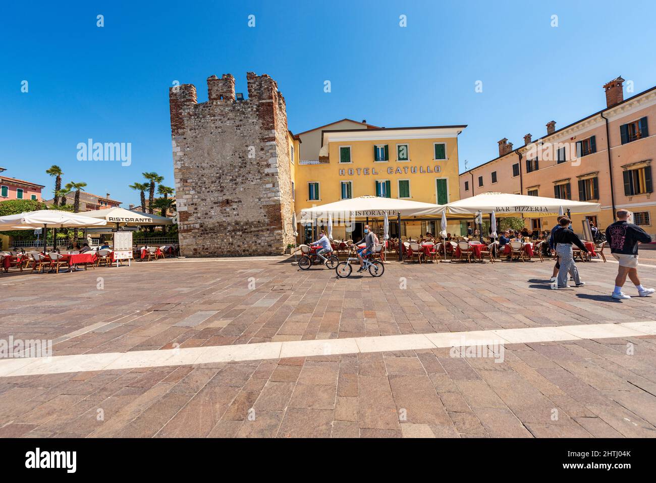 Downtown of Bardolino village. Promenade on the coast of Lake Garda with the medieval tower and restaurants, pizzerias and bars. Verona, Italy. Stock Photo