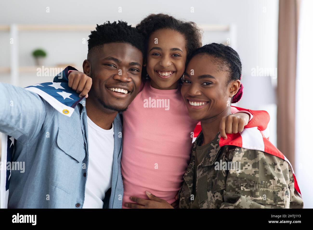 Positive black family posing with flag of the US Stock Photo