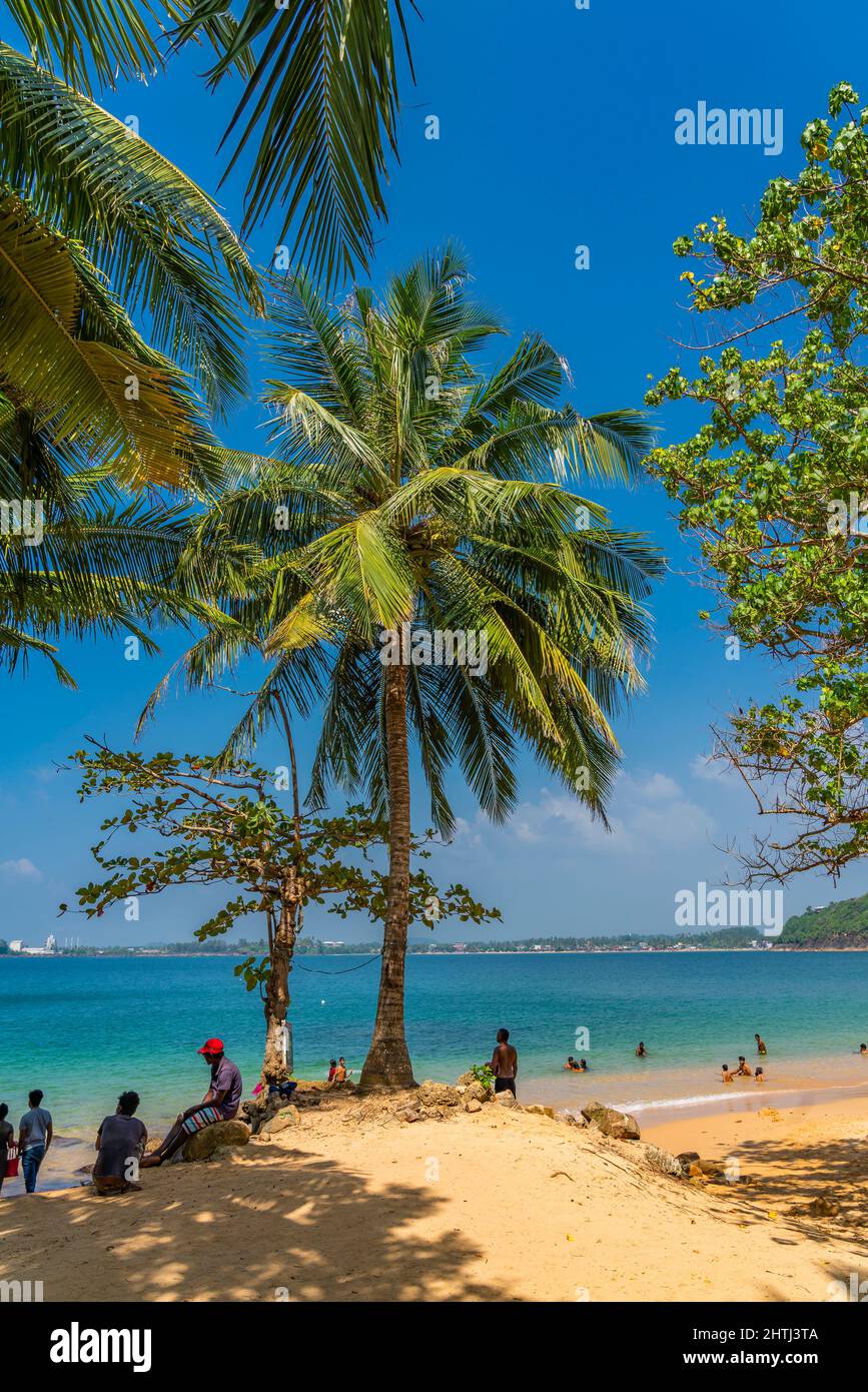 UNAWATUNA, SRI LANKA - DECEMBER 24, 2021: View of the Jungle Beach at Unawatuna, Galle with calm water, vertical Stock Photo