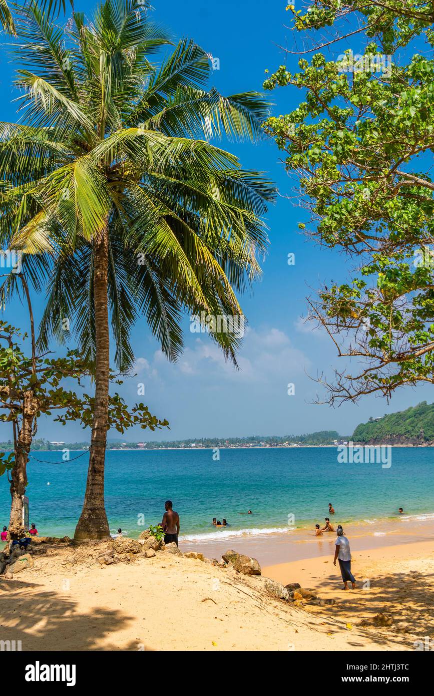 UNAWATUNA, SRI LANKA - DECEMBER 24, 2021: View of the Jungle Beach at Unawatuna, Galle with calm water, vertical Stock Photo