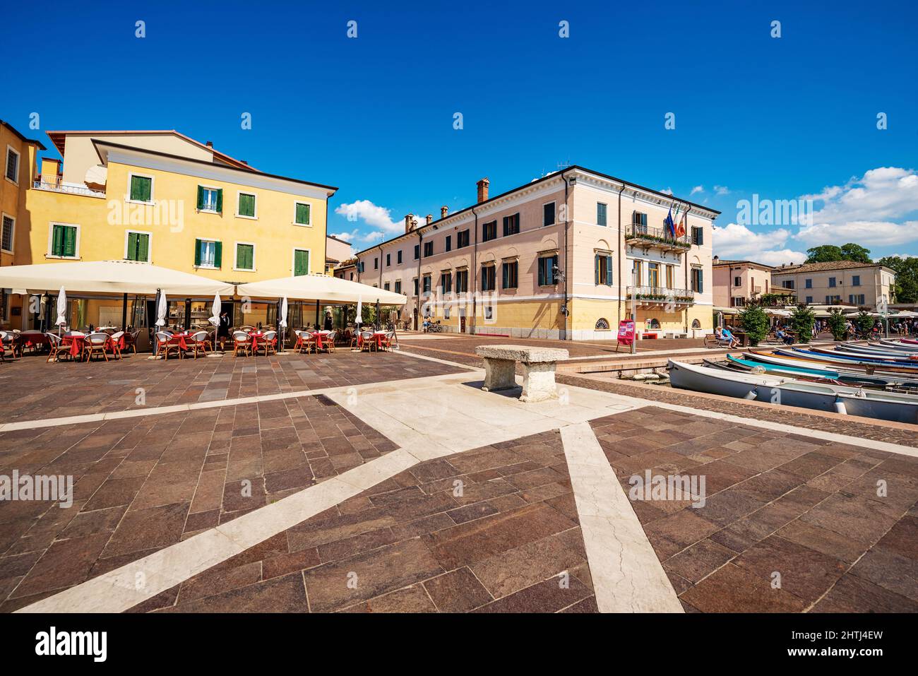 Bardolino village, promenade in front of the small port with a restaurant and the town hall. Tourist resort on Lake Garda in Verona province, Italy. Stock Photo