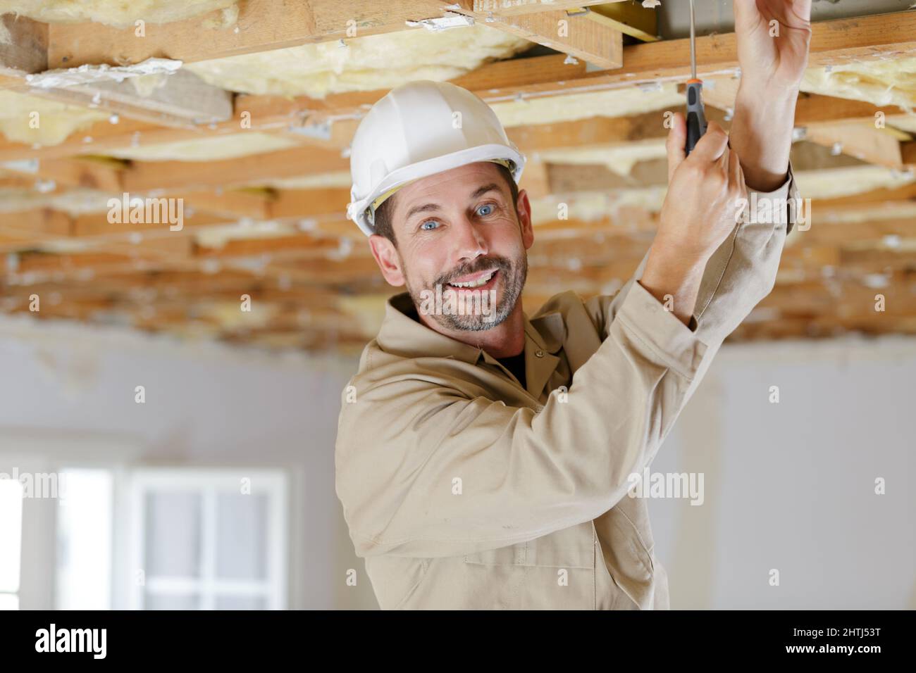 portrait of a master builder screwing ceiling Stock Photo - Alamy