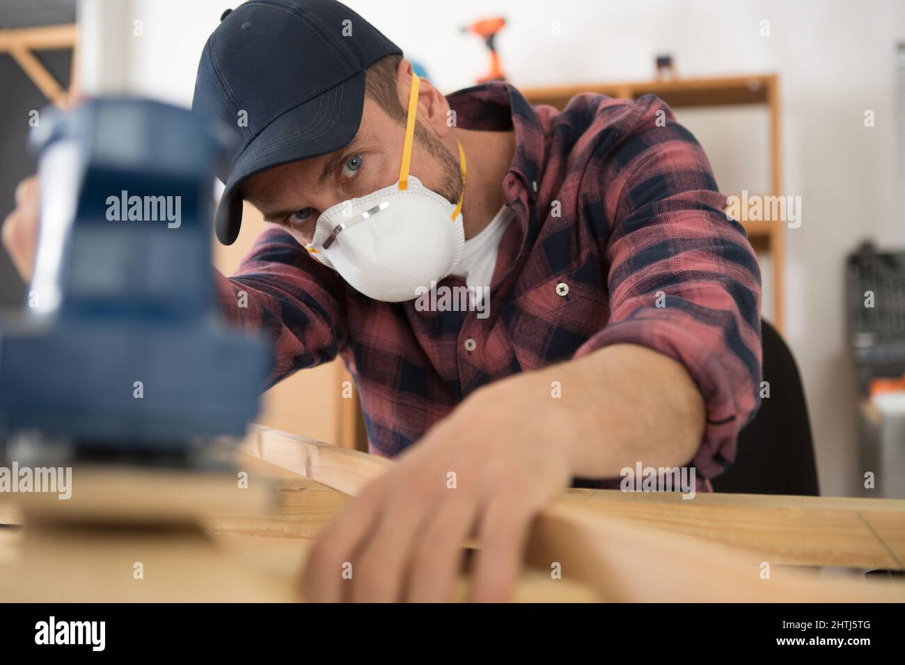 young craftsman wearing a protective mask sanding Stock Photo Alamy