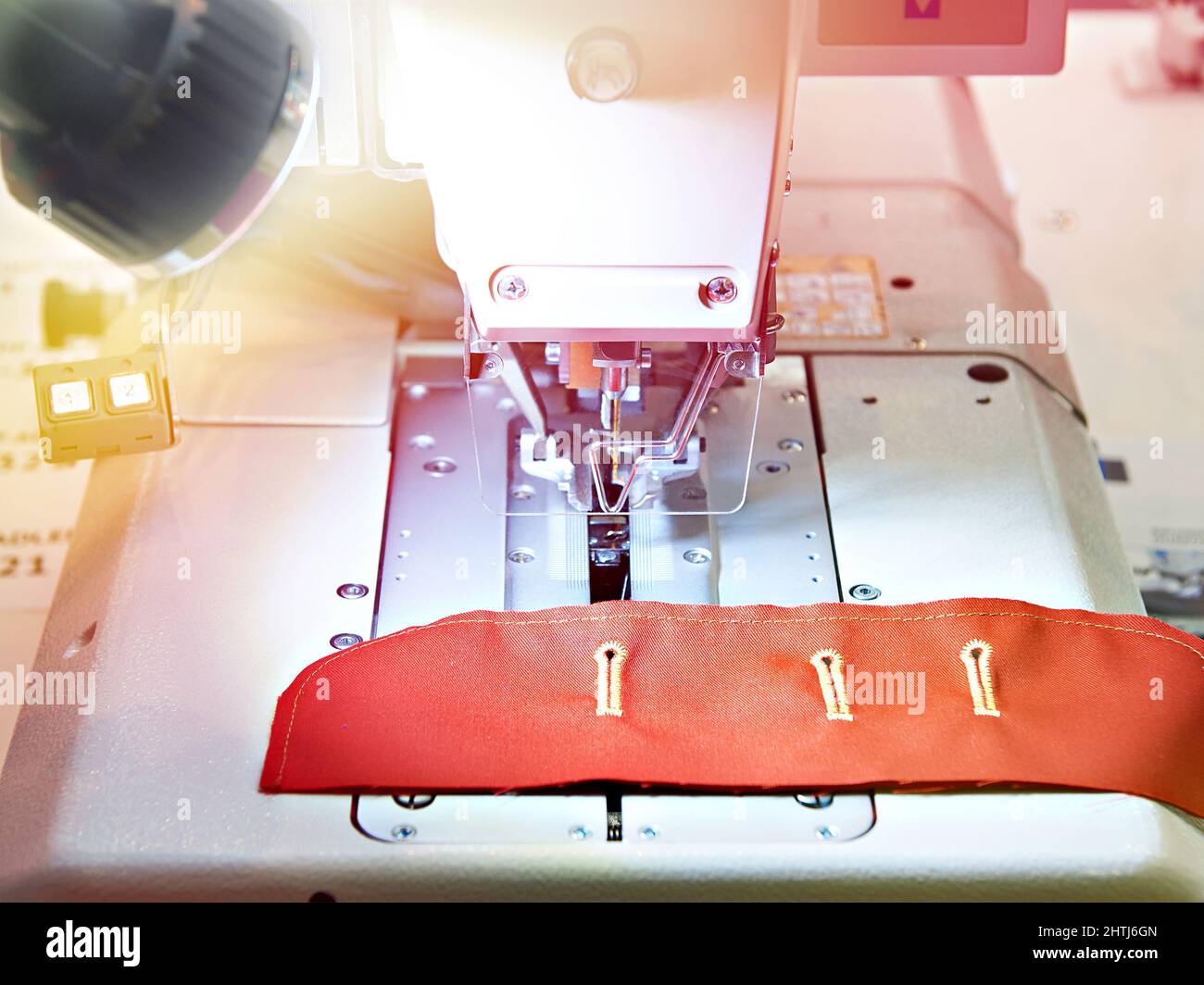 Sewing machine with red cloth button holes Stock Photo Alamy