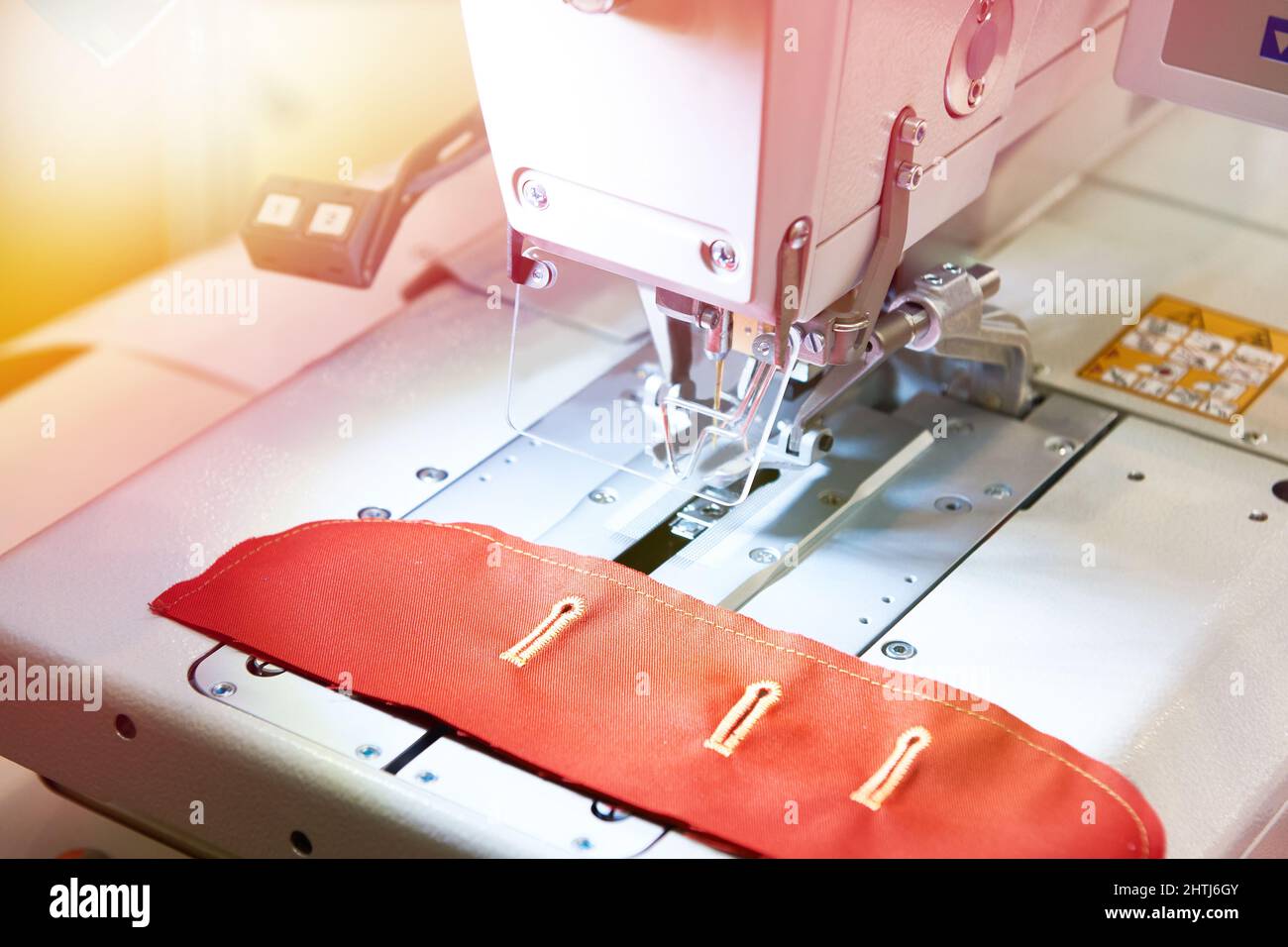 Sewing machine with red cloth button holes Stock Photo Alamy