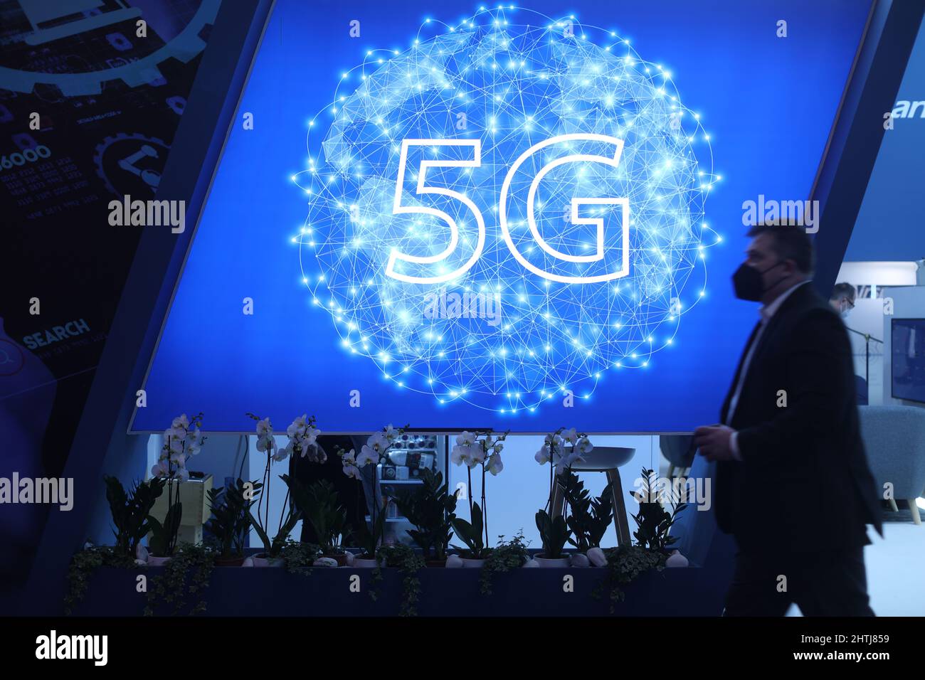 Barcelona, Spain. 28th Feb, 2022. A visitor walks past the a 5G logo at