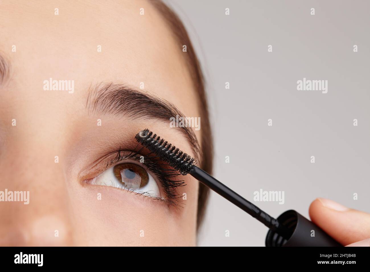 Easy steps to perfect beauty. Closeup shot of a young woman applying mascara in studio. Stock Photo