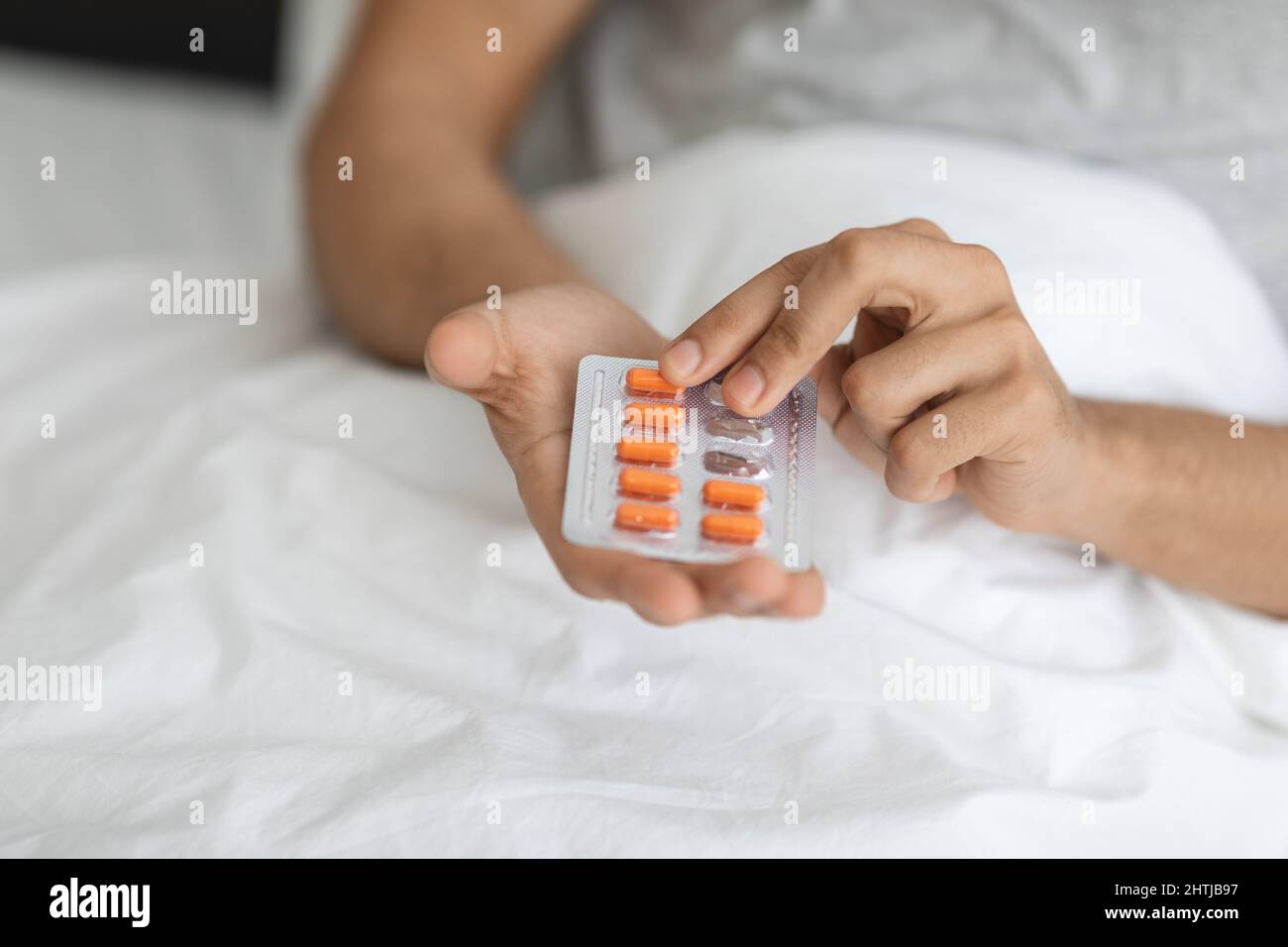 Sick Man Holding Blister Pack With Pills, Taking Medicine At Home Stock Photo