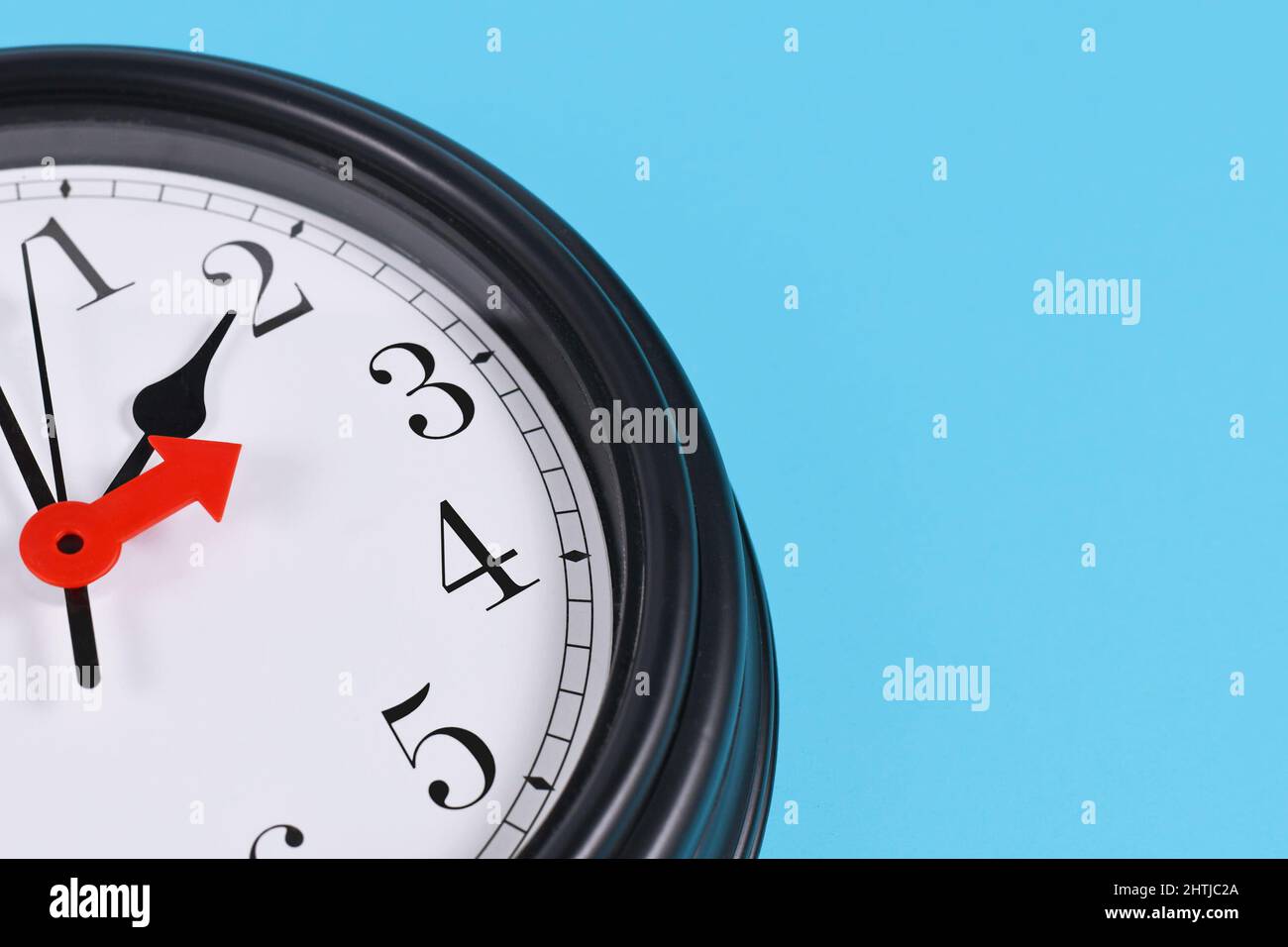 Time change for summer daylight saving in Europe concept. Red arrow symbolizing clock turned forward by one hour Stock Photo