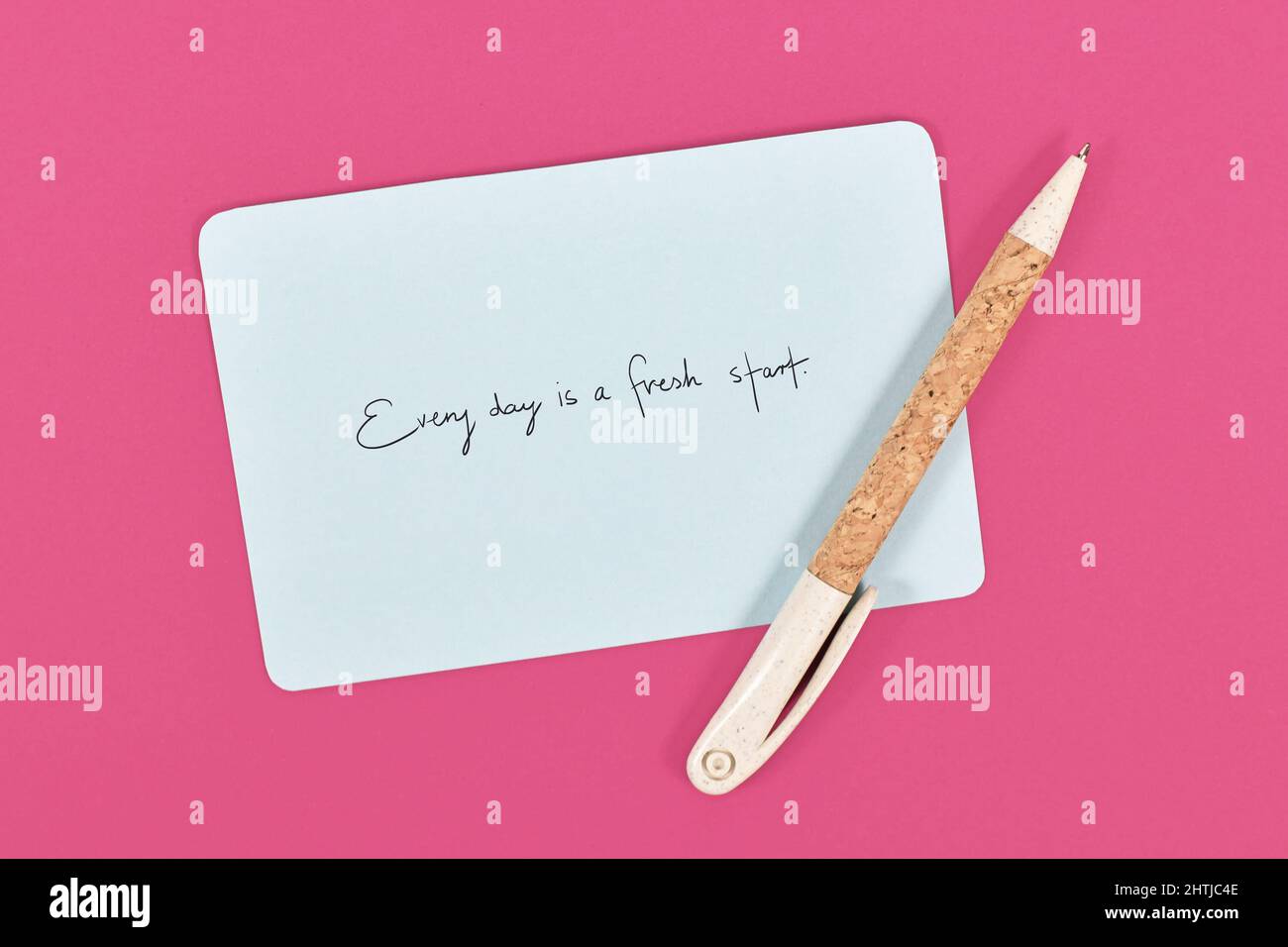 Motivational text 'Every day is a fresh starts' on blue paper note on pink background Stock Photo