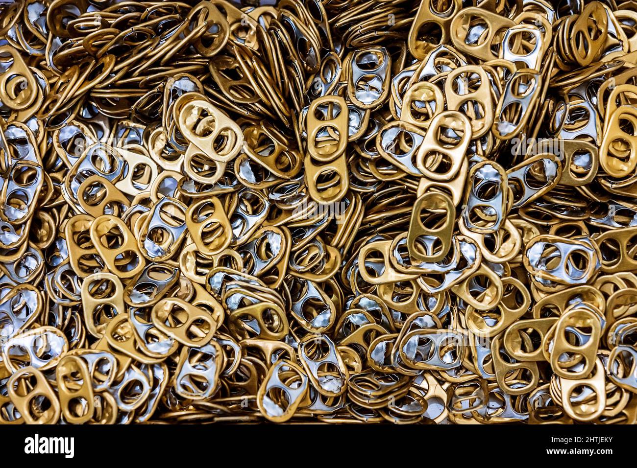From above full frame pile of golden aluminum ring pulls from metal