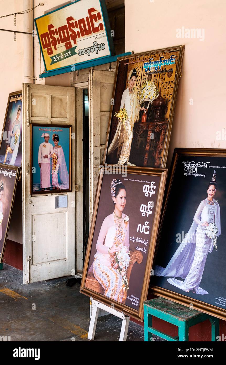 Rangoon, Myanmar - 04.19.2017: Collection of photos from wedding ceremonies in frames at entrance of local photography studio Stock Photo