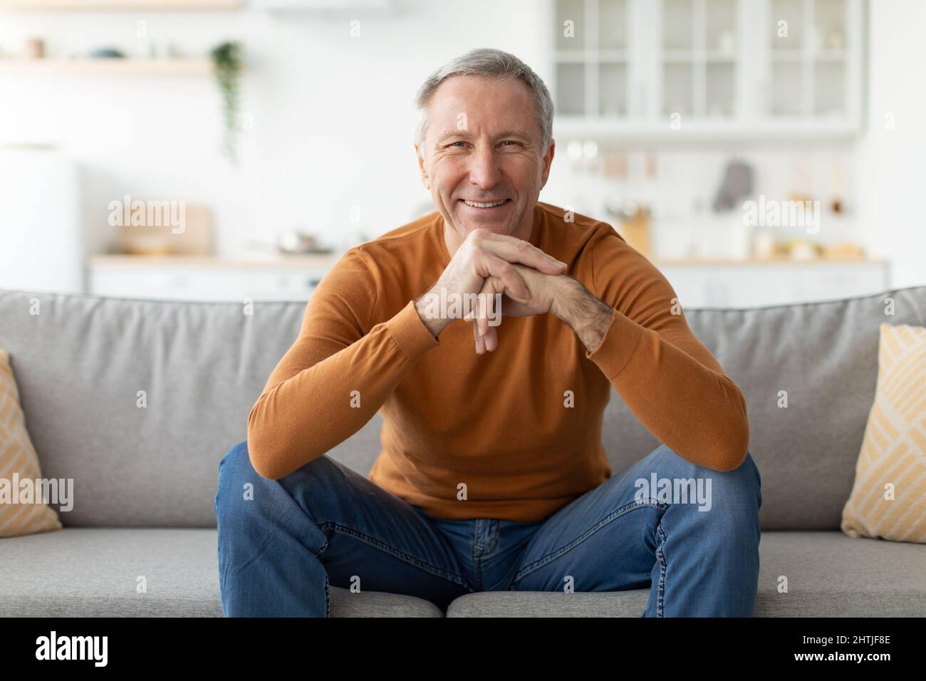 Mature man having rest at home on the couch Stock Photo