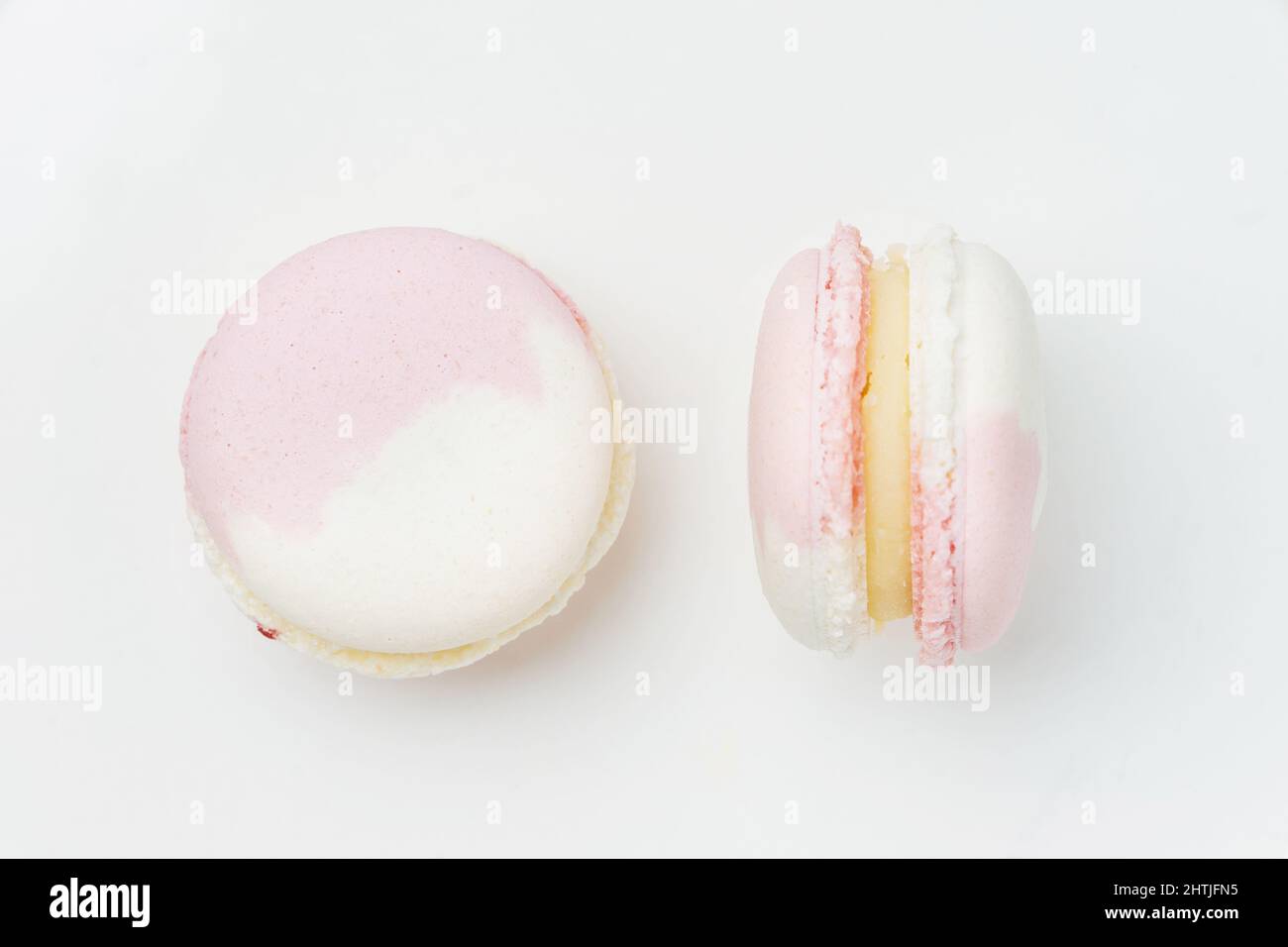 Sweet round pink and white macaroons with filling served on white ...