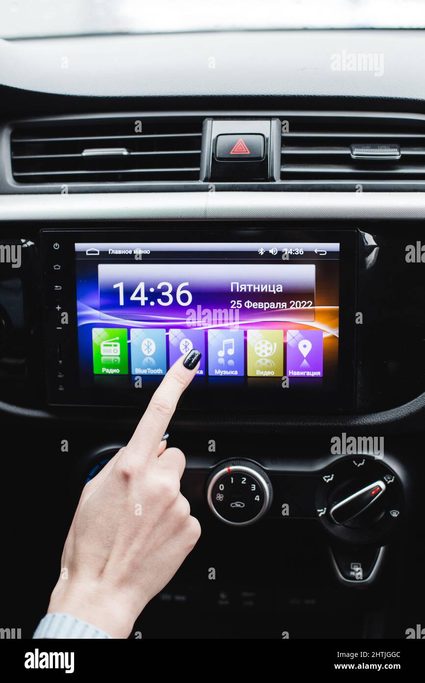 Woman is pairing her phone with car music system via bluetooth Stock Photo