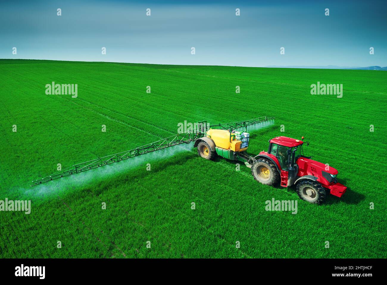 Aerial view of farming tractor plowing and spraying on field Stock ...